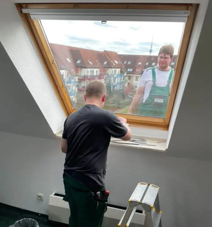 Monteur tauscht von innen die Verglasung eines Dachfensters